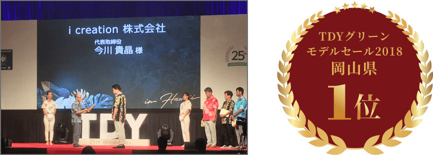 TDYグリーンモデルセールの授賞式のステージに立つイマガワリフォーム代表とTDYグリーンモデルセール2018岡山県1位のエンブレム